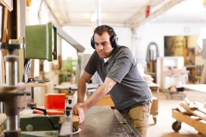 Carpenter in workshop with electric cutter