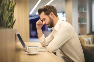 man in pain at desk